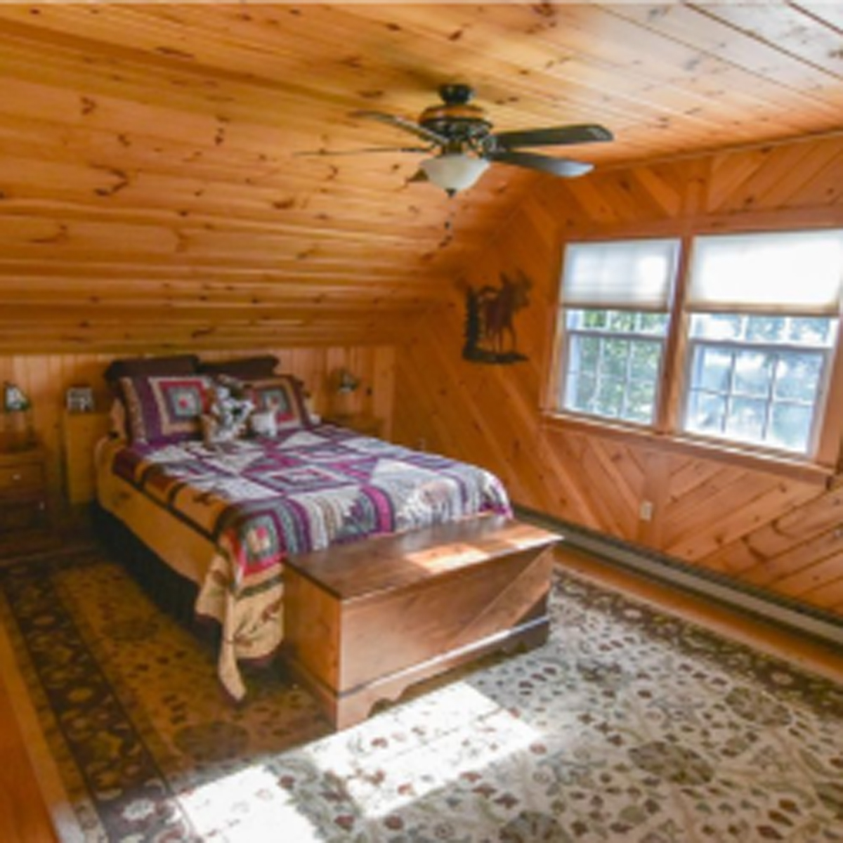 master bedroom with knotty-pine walls and queen bed